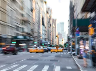  Fast moving taxis on Fifth Avenue in Manhattan New York City blurred background © deberarr