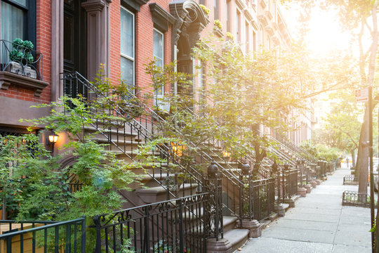 Sunlight shines on historic brownstone buildings in Manhattan New York City
