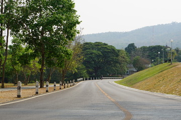 Fototapeta na wymiar The road has a curved path and green grassy hillsides.
