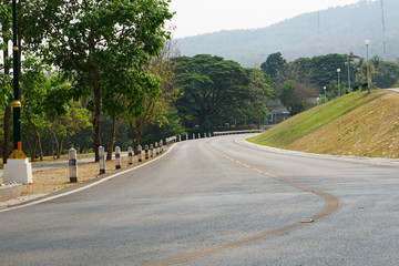 The road has a curved path and green grassy hillsides.