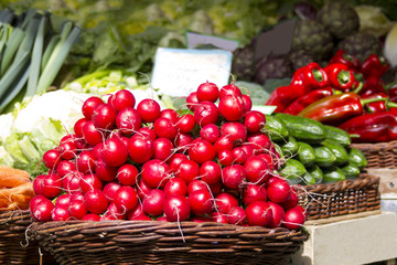 Fresh red radishes in a basket on a farmer market store for presentation with other healthy biological foods