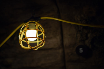 Fototapeta na wymiar Yellow lamp in underground cave or mine.