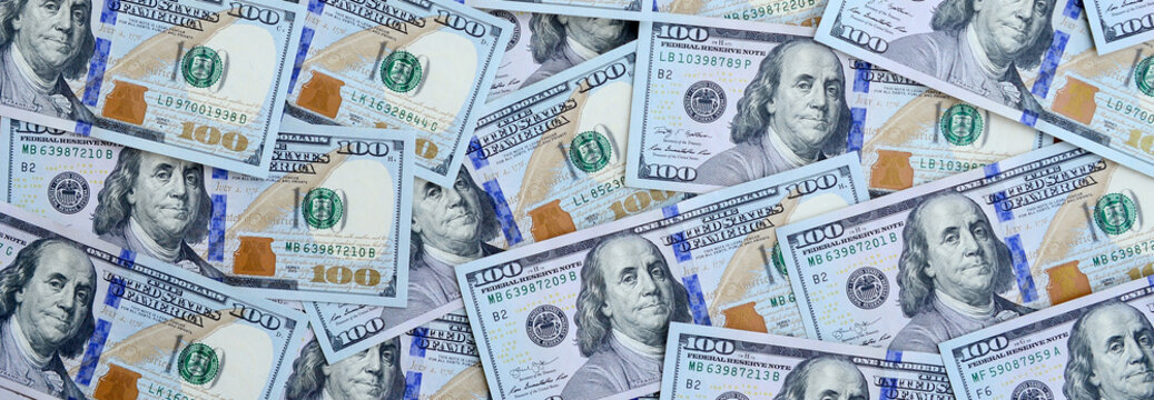 A large number of US dollar bills of a new design with a blue stripe in the middle. Top view