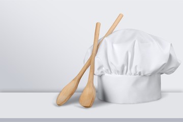 White cooks cap and wooden spoons
