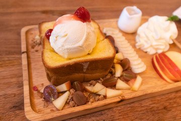 Obraz na płótnie Canvas Honey toast with ice cream topping on wood table 