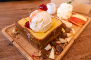 Honey toast with ice cream topping on wood table
