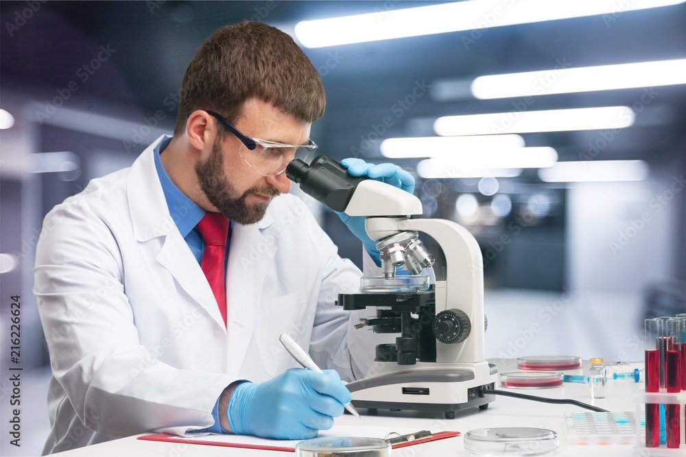 Wall mural Young male scientist Working with Microscope