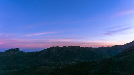 Obraz premium Pink sunset with mountain silhouette in background