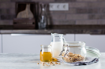 Breakfast Food Concept. Homemade Granola, milk or , and honey on table background on the kitchen. Copy space