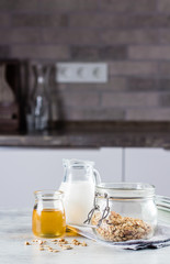 Breakfast Food Concept. Homemade Granola, milk or , and honey on table tabckground on the kitchen. Copy space