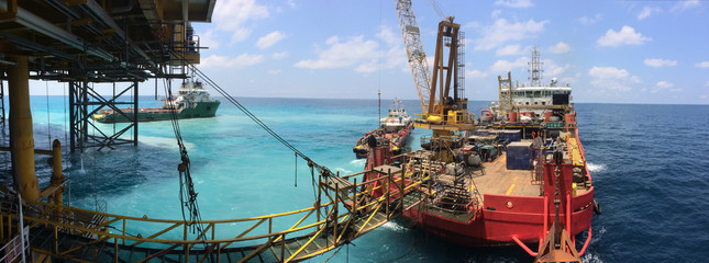Accommodation work vessel connects to platform via gangway during simultaneous operations with jack...