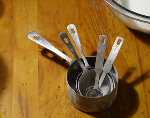 Set of stainless steel dry measuring cups with flour on them