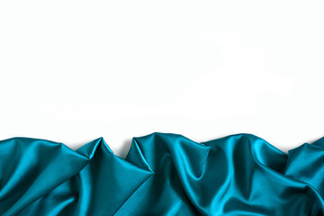 Close up of ripples in aquamarine silk fabric. Satin textile background with free copy space on white. - 216231680