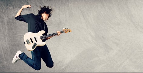 Portrait of a Musician Jumping while Playing - obrazy, fototapety, plakaty