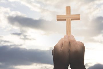 Human hand holding a cross, the background is the sunrise., Concept for Christian, Christianity,...
