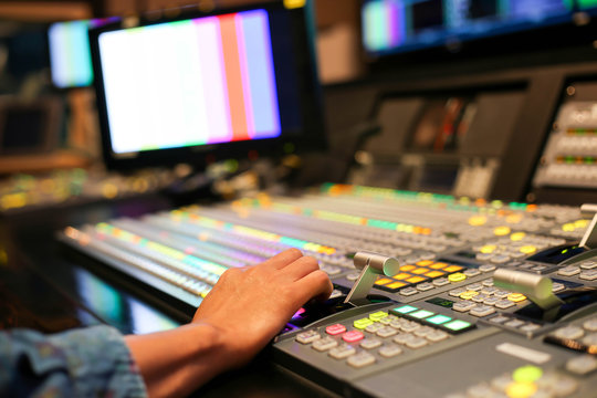 Hands on dissolve of Switcher buttons in studio TV station, Audio and Video Production Switcher of Television Broadcast.