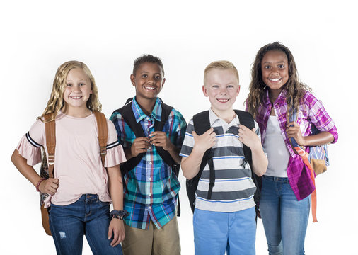Group portrait of pre-adolescent school kids smiling on a white background. Back to school photo of a diverse group of children wearing backpacks isolated on a white background