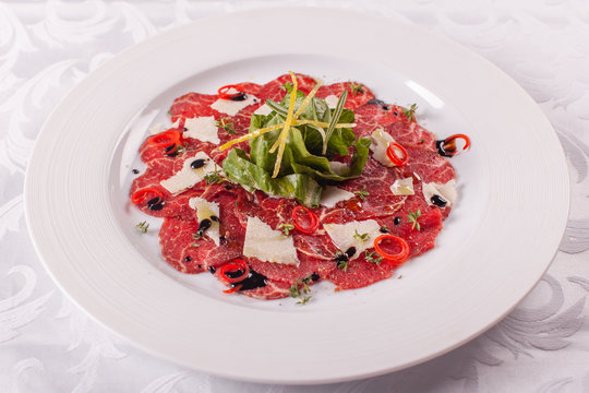 Carpaccio , beef steak salad. Summer launch, healthy eating concept. white plate with sauce. salad served in italian style