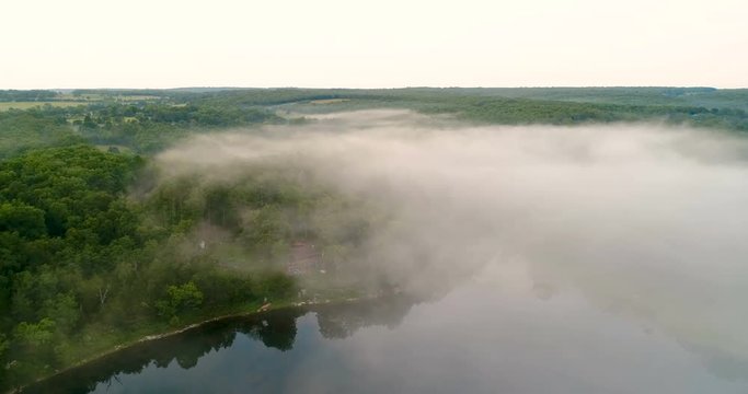 Aerial flight over a lake with fog
