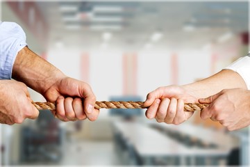 Business people pulling rope in opposite directions
