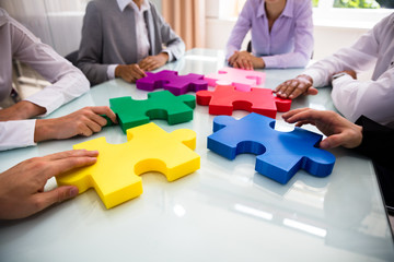 Group Of Businesspeople Solving Jigsaw Puzzle