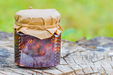 Still life with young pine cones jam on wooden stump. Useful and tasty dessert with copyspace