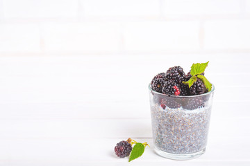 Fototapeta na wymiar Food and drink, healthy eating and dieting concept. Homemade white chia pudding with fresh berries and green leaves for breakfast on a light kitchen table. Copy space.