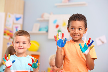 Cute boys with painted palms indoor