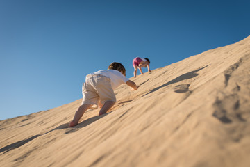 Children having fun on the sand dune