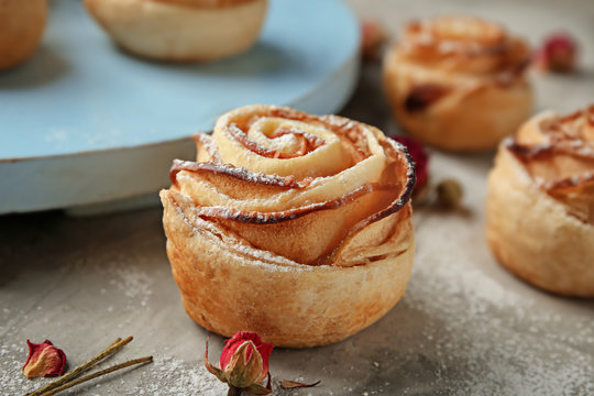 Tasty apple rose from puff pastry on table