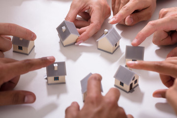 Group Of People Touching Miniature House