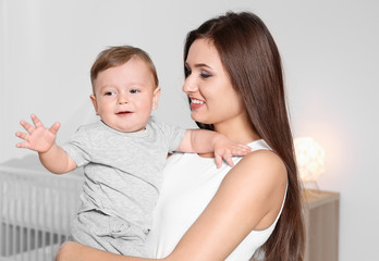 Happy young mother with her cute little baby at home