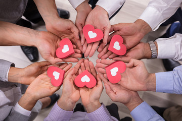 Businesspeople Holding Red Hearts