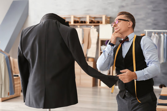 Mature man checking jacket on mannequin in atelier