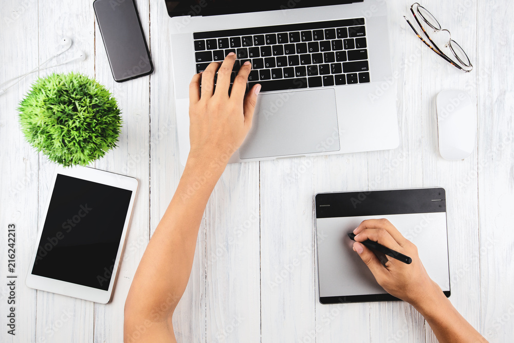Poster graphic designer using laptop and graphic tablet on top view