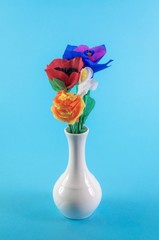 Naklejka premium Origami flowers. Paper flowers. Handmade flowers in a ceramic vase on blue background.