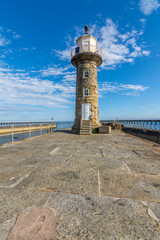 Whitby Lighthouse against blue sky - North Yorkshire, England