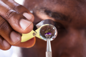 Obraz premium Jeweler Examining Diamond Through Loupe