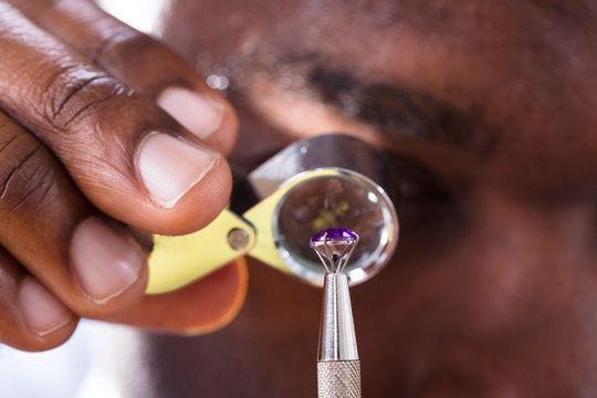 Jeweler Examining Diamond Through Loupe