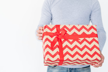 holiday present in a big gift box with red chevron pattern and a bow. christmas or new year festive...