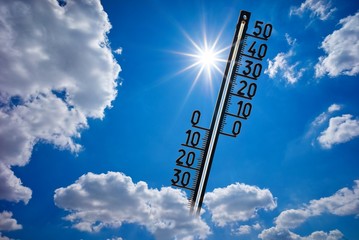 Thermometer mit strahlender Sonne, blauem Himmel und Wolken