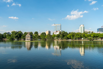 Hoan Kiem lake or Sword lake, Ho Guom in Hanoi, Vietnam with Turtle Tower, on clear day with blue sky and white clouds