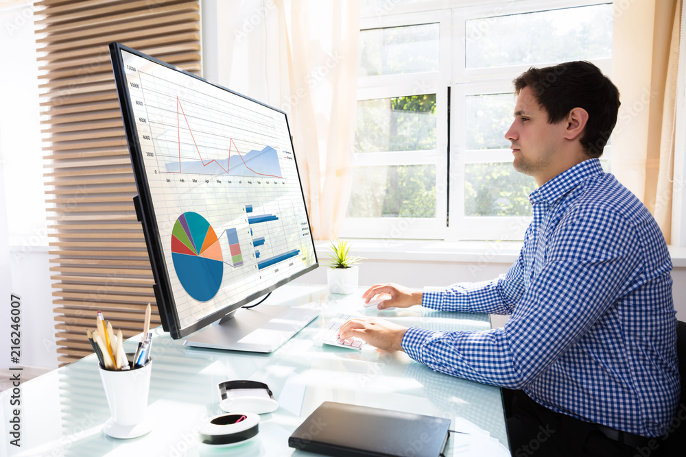 Poster Businessman analyzing graphs on computer