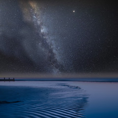 Fototapeta na wymiar Vibrant Milky Way composite image over landscape of view along beach at low tide