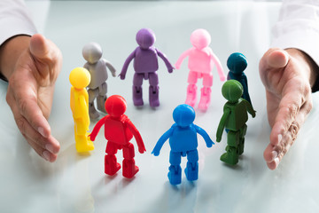 Person protecting multi colored human figures