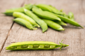 fresh green pea pods from the garden on a wooden background