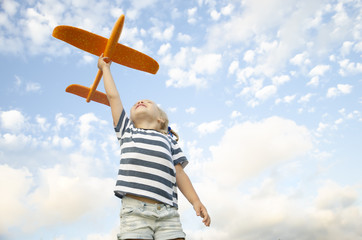 The child plays with a plane and launches it into the sky