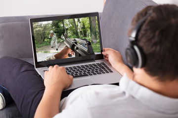 Man playing shooting game on laptop