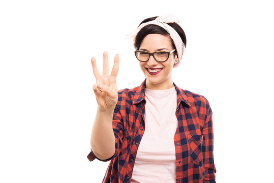 Pretty pin-up girl wearing glasses showing number three with fingers.