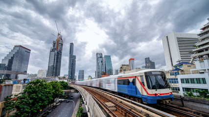 Naklejka premium Sky train, mass transportation pass through skycrapers business building in central business district of Bangkok, Thailand
